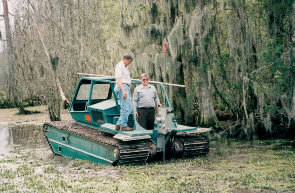 Two men aboard a Marsh Master® marsh buggy in a swamp.