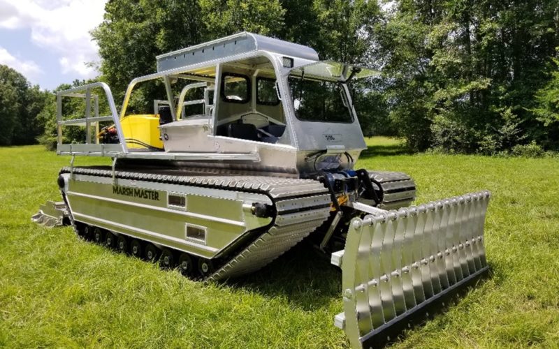 A Marsh Master® MM2-LX equipped with a hydraulic front hitch with blade attachment for vegetation clearing