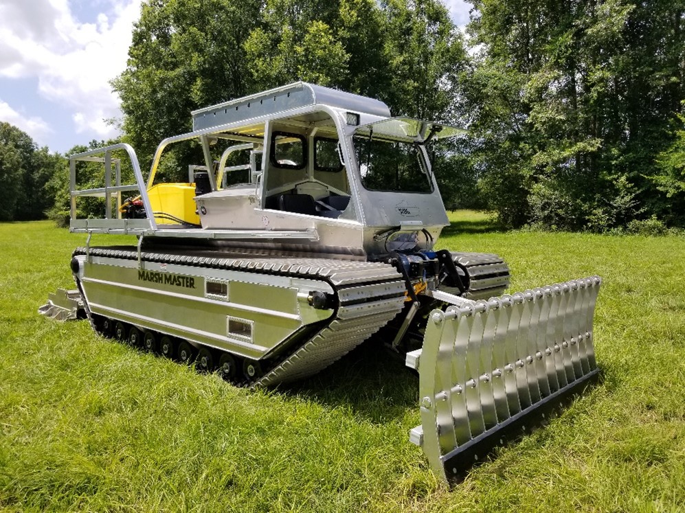 A Marsh Master® MM2-LX equipped with a hydraulic front hitch with blade attachment for vegetation clearing